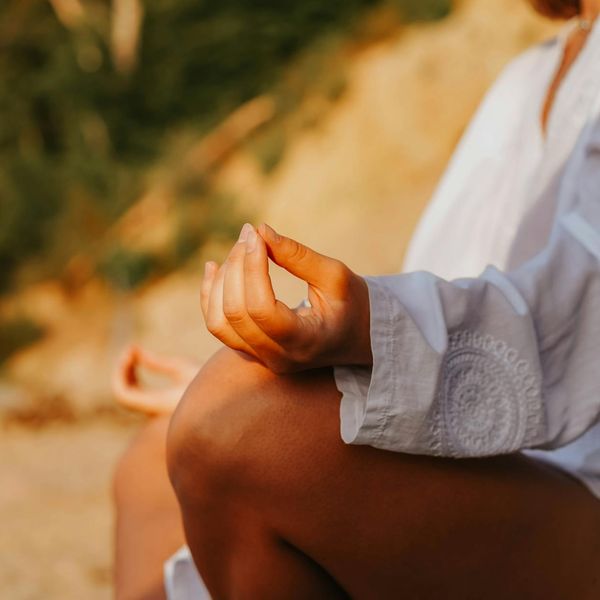 Close-up of hands in a meditative mudra gesture, calm and focused.